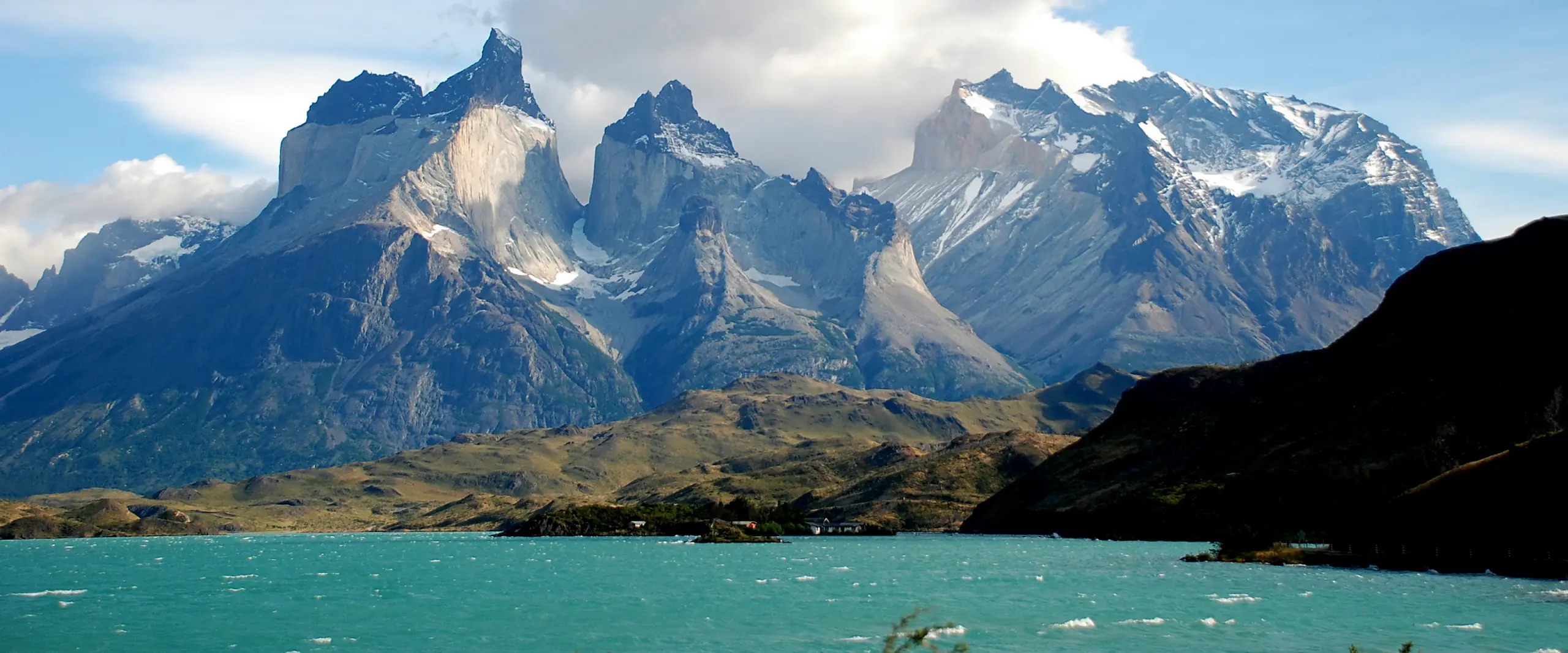 Picos de granito de Torres del Paine acima das águas azul-turquesa na Patagônia chilena.