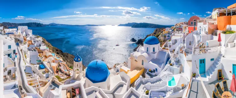 Whitewashed buildings and blue-domed churches in Oia overlooking the Santorini caldera.