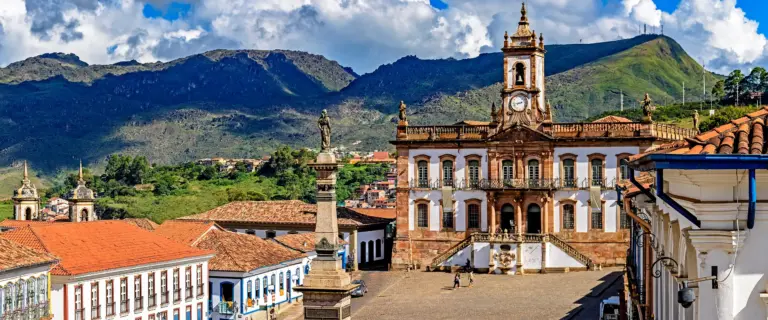 Praca Tiradentes e Museu da Inconfidencia cercados por edificios coloniais e montanhas em Ouro Preto, Minas Gerais.