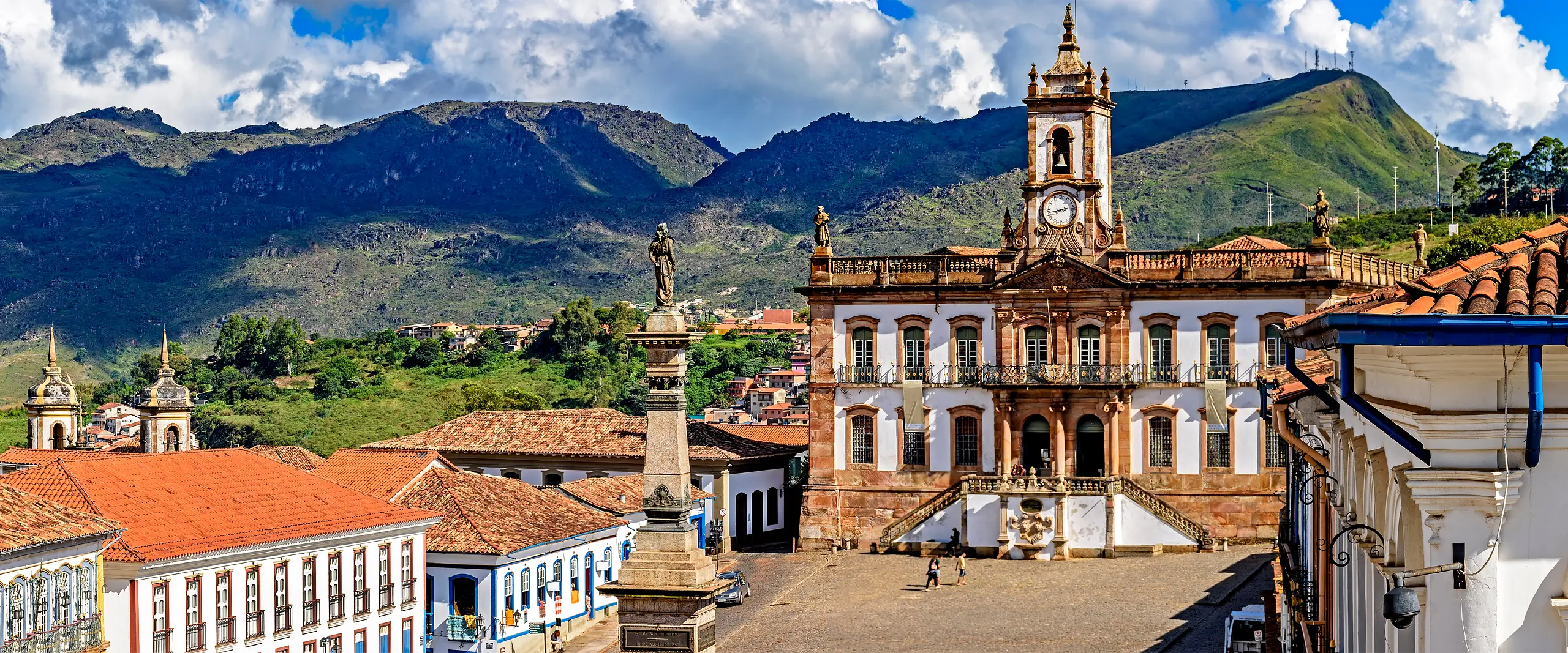 Praca Tiradentes e Museu da Inconfidencia cercados por edificios coloniais e montanhas em Ouro Preto, Minas Gerais.