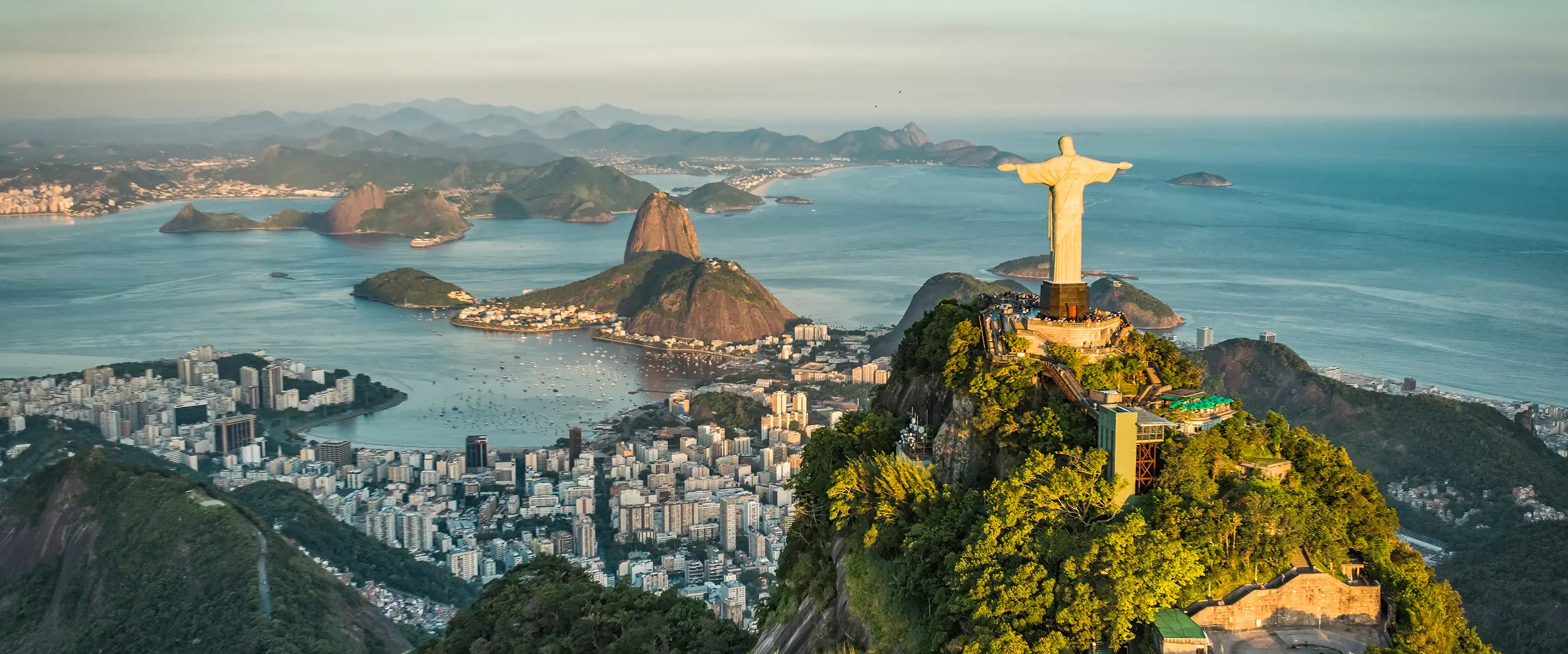 Aerial view of Christ the Redeemer on Corcovado Mountain overlooking Botafogo Bay, Sugarloaf Mountain, and Rio de Janeiro.