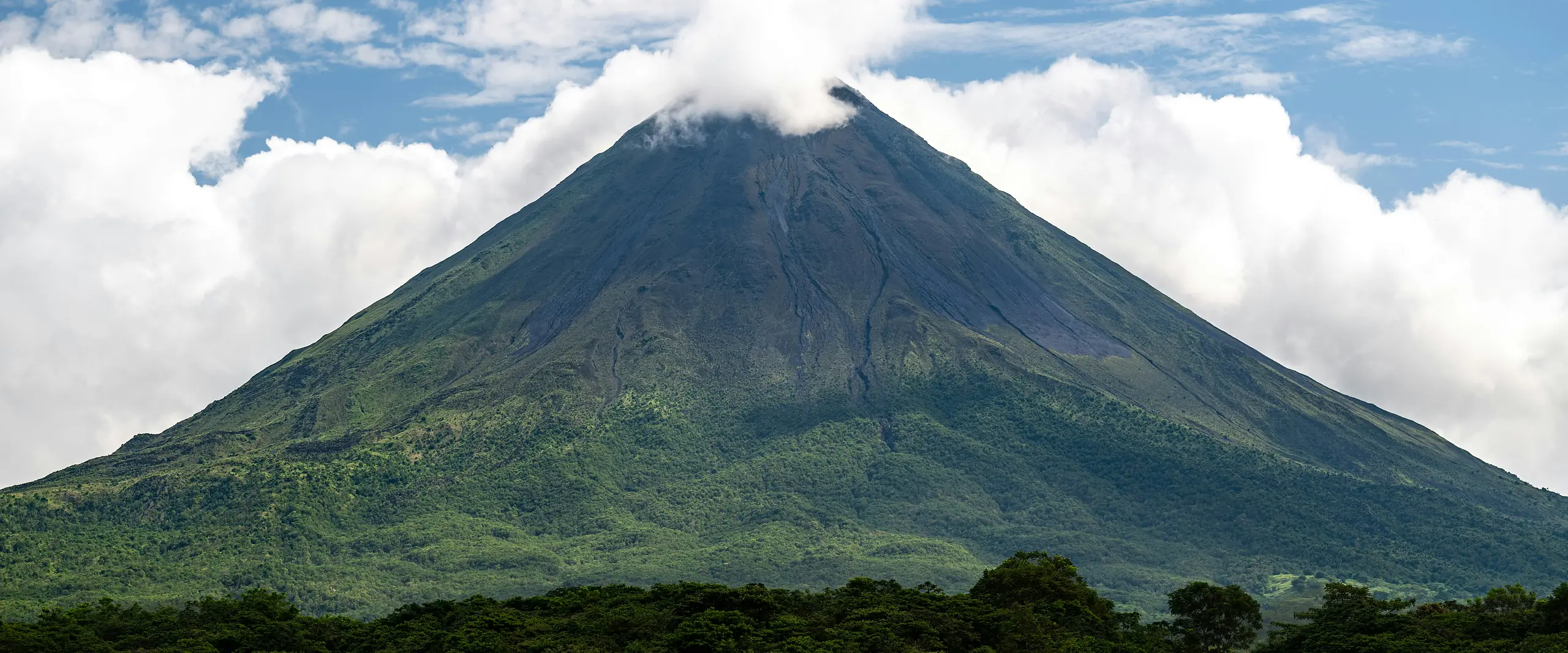 Arenal Volcano rising above green forest in Costa Rica