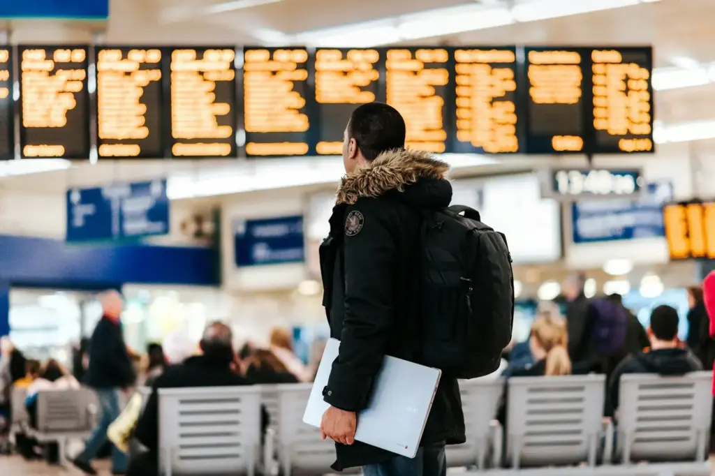Passageiro consultando conexões internacionais no painel de voos do aeroporto